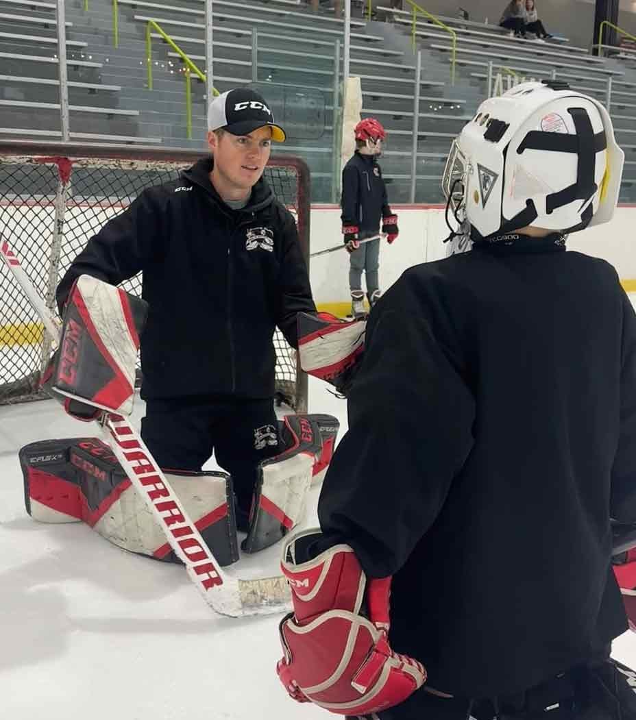 Youth hockey team with coaches during ice practice — Coach Utah explains why goalie development needs a structured system